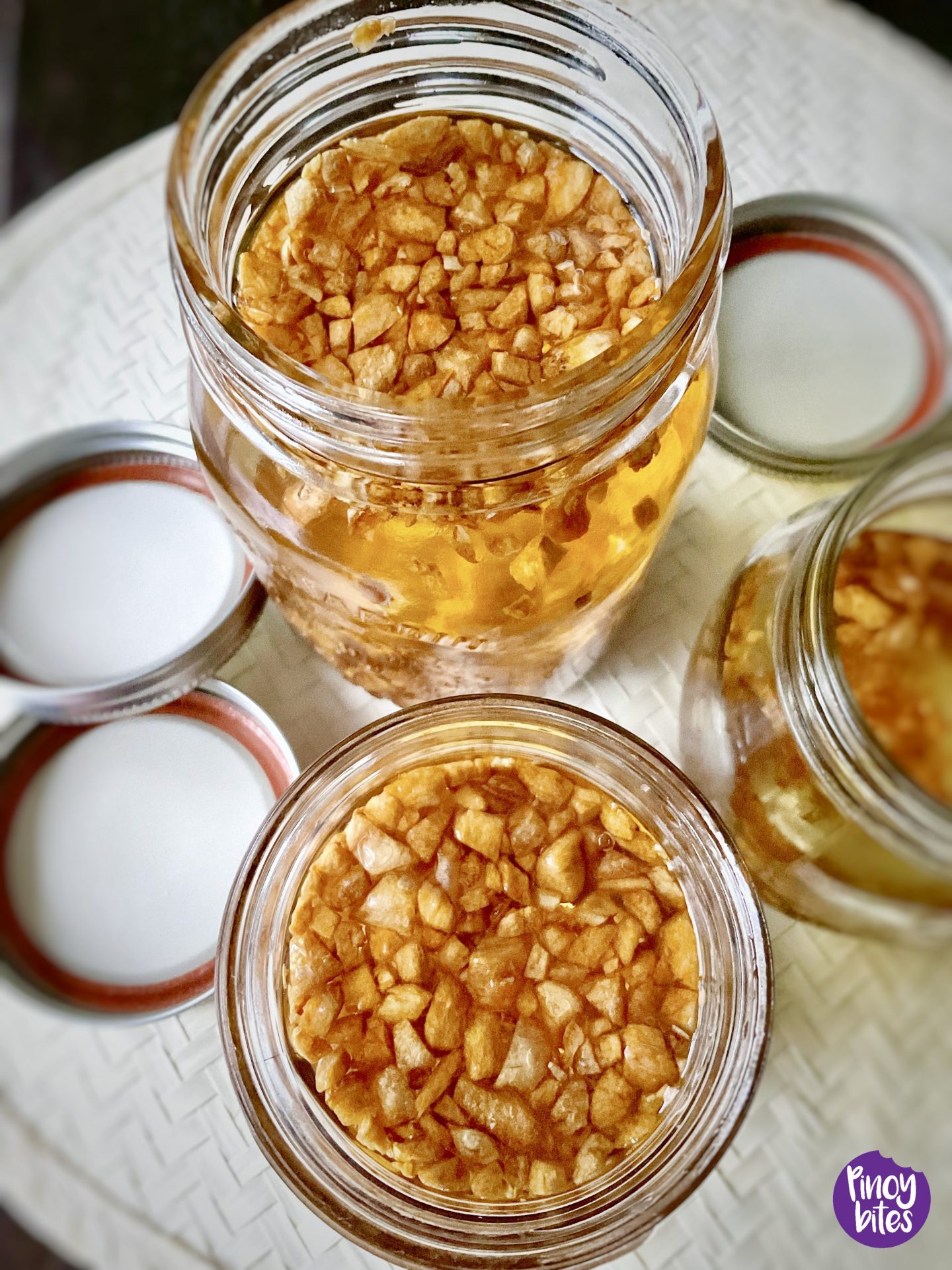 Garlic oil dalam wadah kaca bersih dengan potongan bawang putih goreng yang renyah