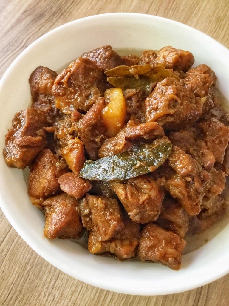 a bowl of meat with leaves